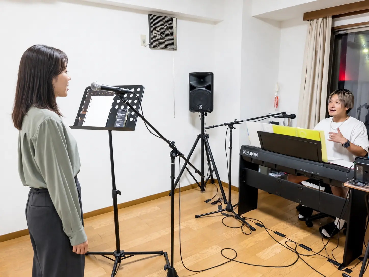 KUMAが生徒の歌唱を確認しながら指導しているレッスン風景